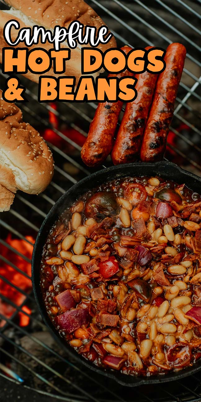 Campfire hot dogs and beans sizzle together in a cast iron skillet over the grill, with fresh buns waiting on the side.