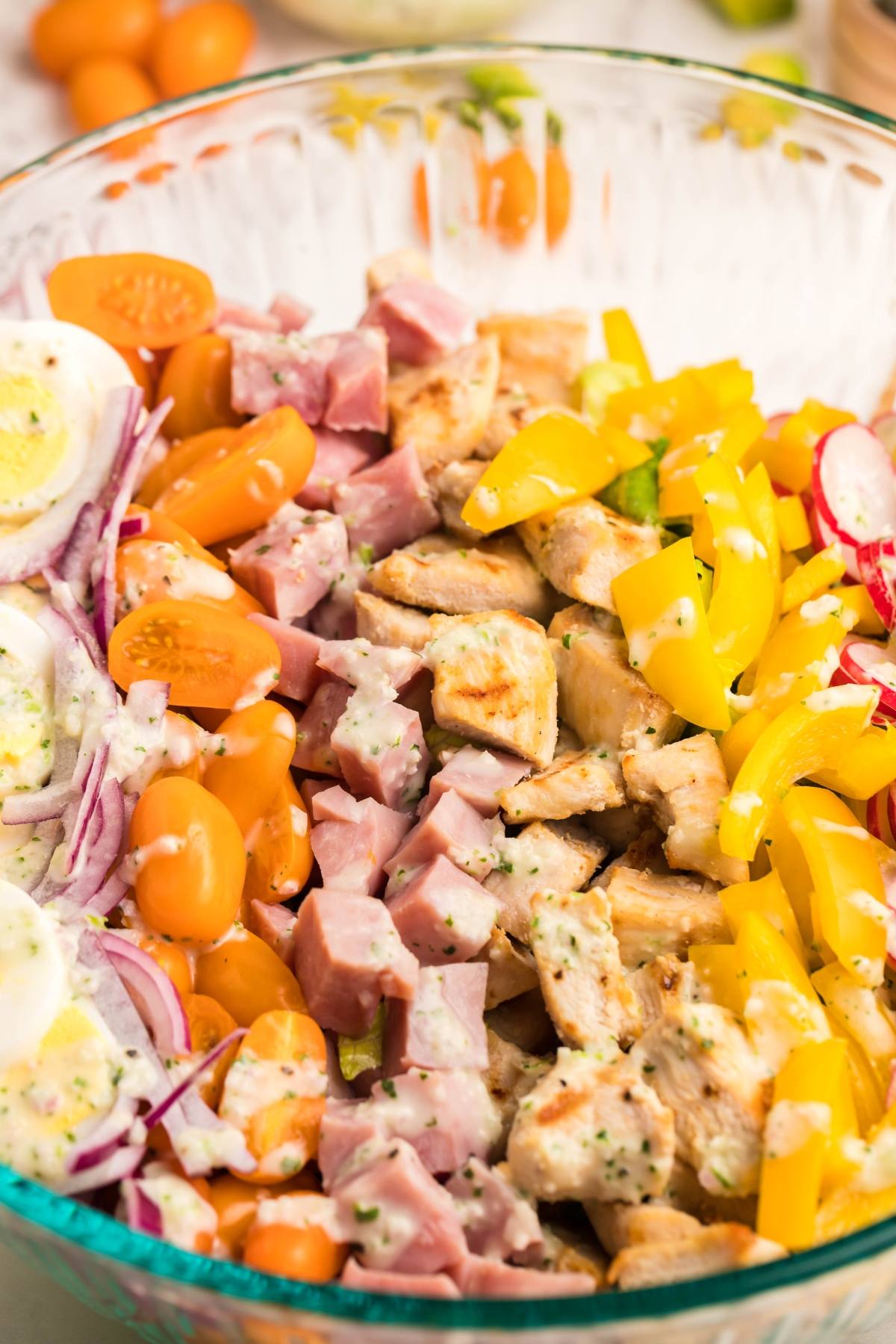 Filling dinner salad with sliced eggs, grilled chicken, yellow peppers, tomatoes, radishes, red onions, and a recipe using leftover ham—all tossed in a dairy free ranch dressing.