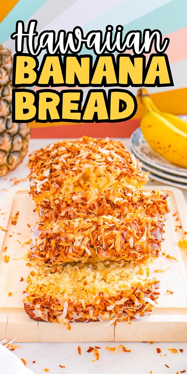 Sliced Hawaiian banana bread topped with toasted coconut sits on a cutting board, surrounded by ripe bananas and a fresh pineapple.