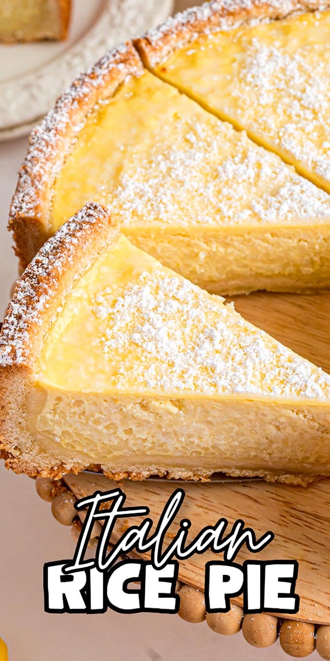 A sliced Italian rice pie with a golden crust, dusted with powdered sugar on a wooden platter, showcases the classic sweetness and creamy texture of this beloved Italian dessert.