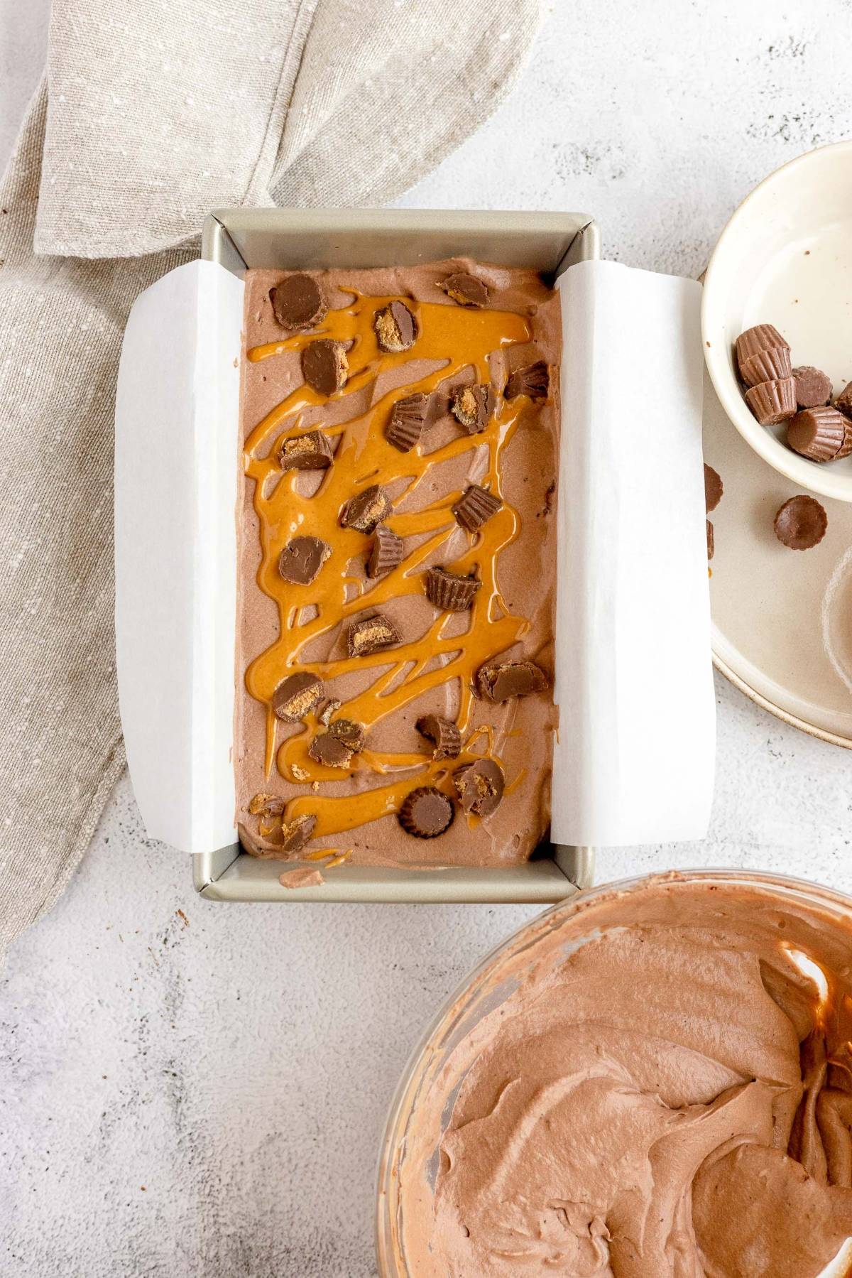 No Churn Chocolate Peanut Butter Cup Ice Cream in a loaf pan, drizzled with peanut butter and loaded with mini peanut butter cups—a dreamy recipe with peanut butter cups for every Reese’s ice cream lover.