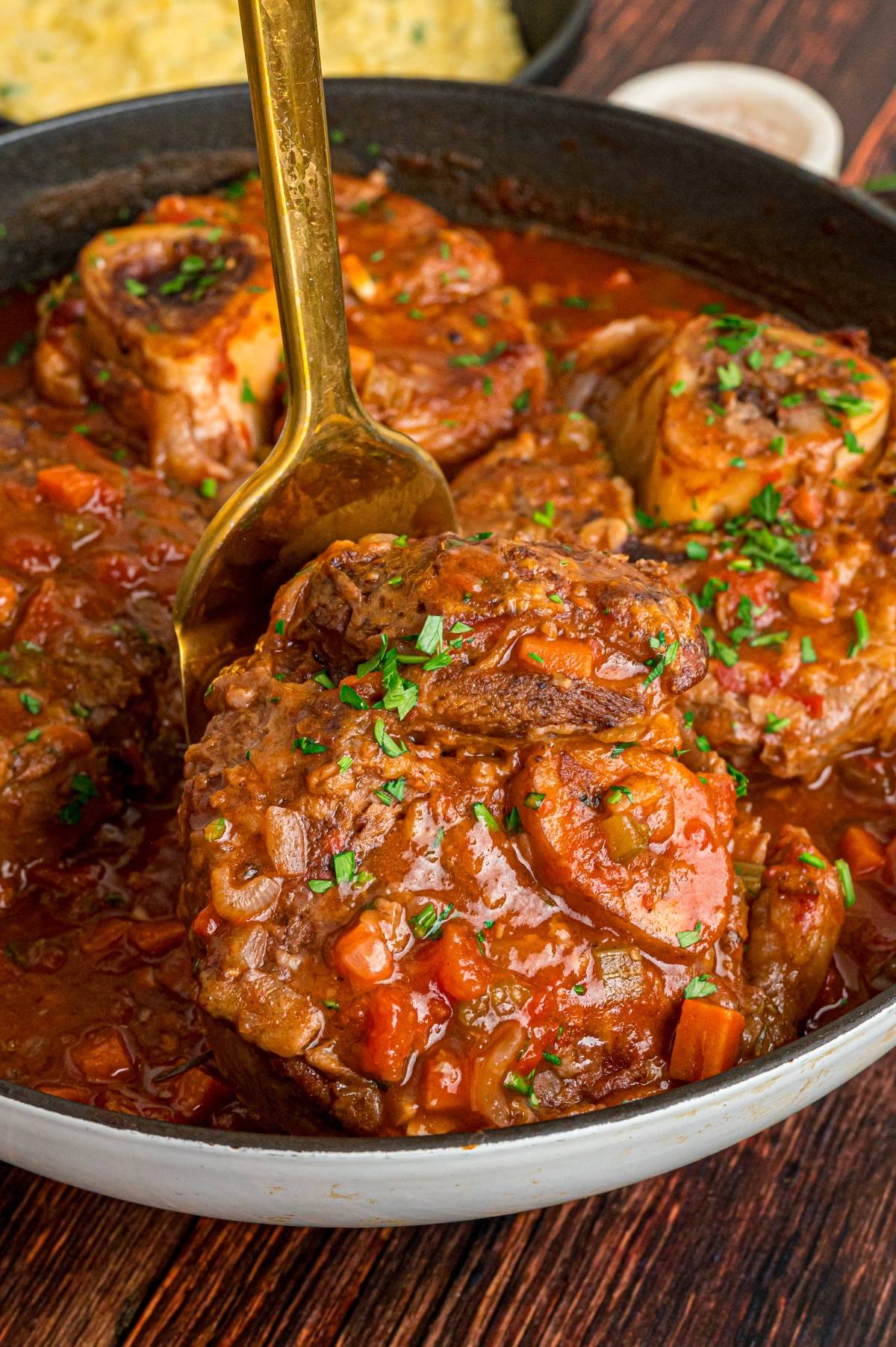 A pot of osso buco with a spoon.