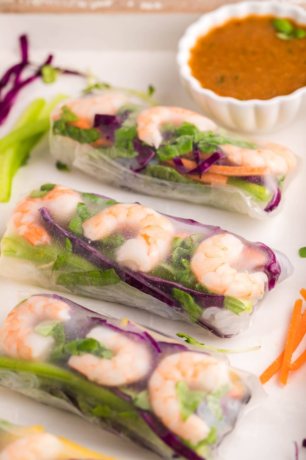 Fresh Vietnamese spring rolls with shrimp and crisp vegetables on a plate, served alongside a flavorful dipping sauce for spring rolls.