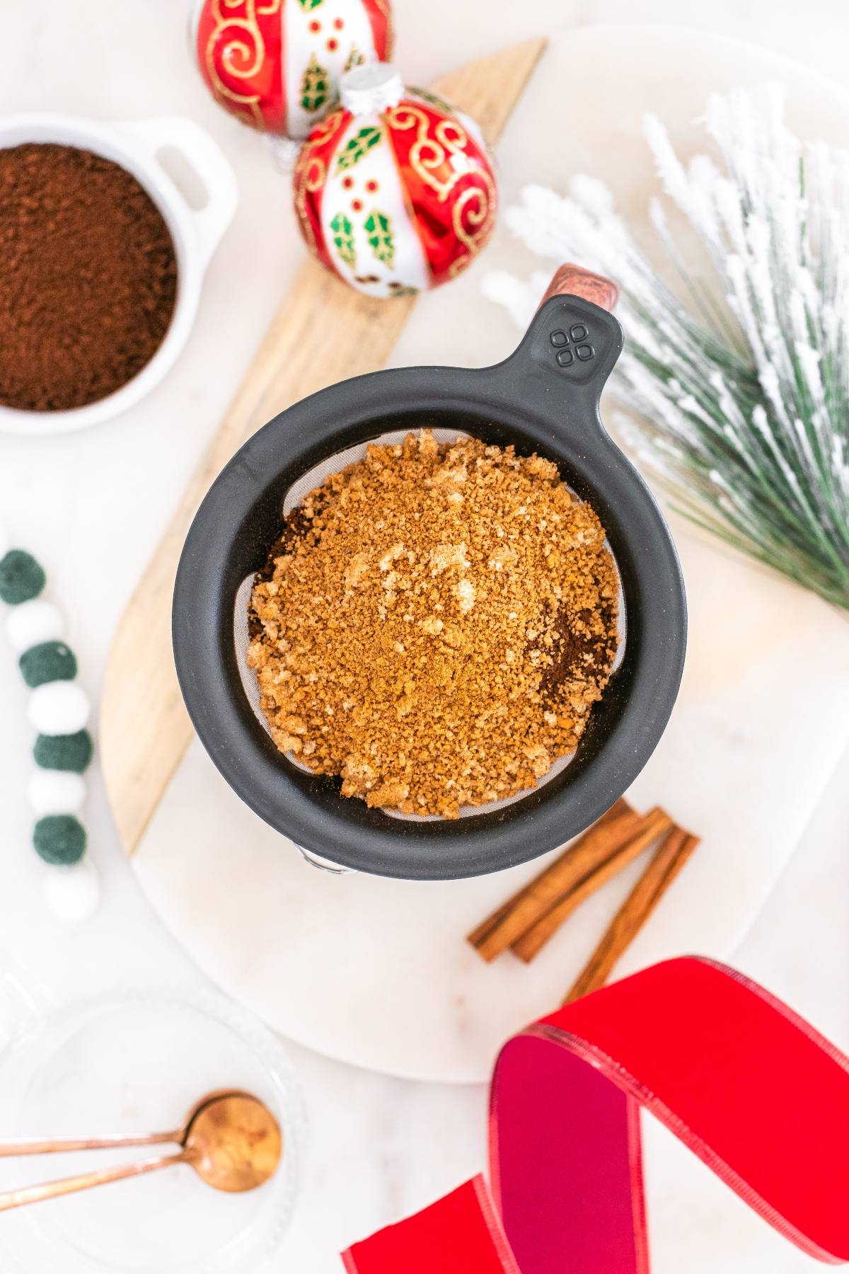 Top view of a cup with brown sugar topping, surrounded by festive holiday decorations and ingredients.