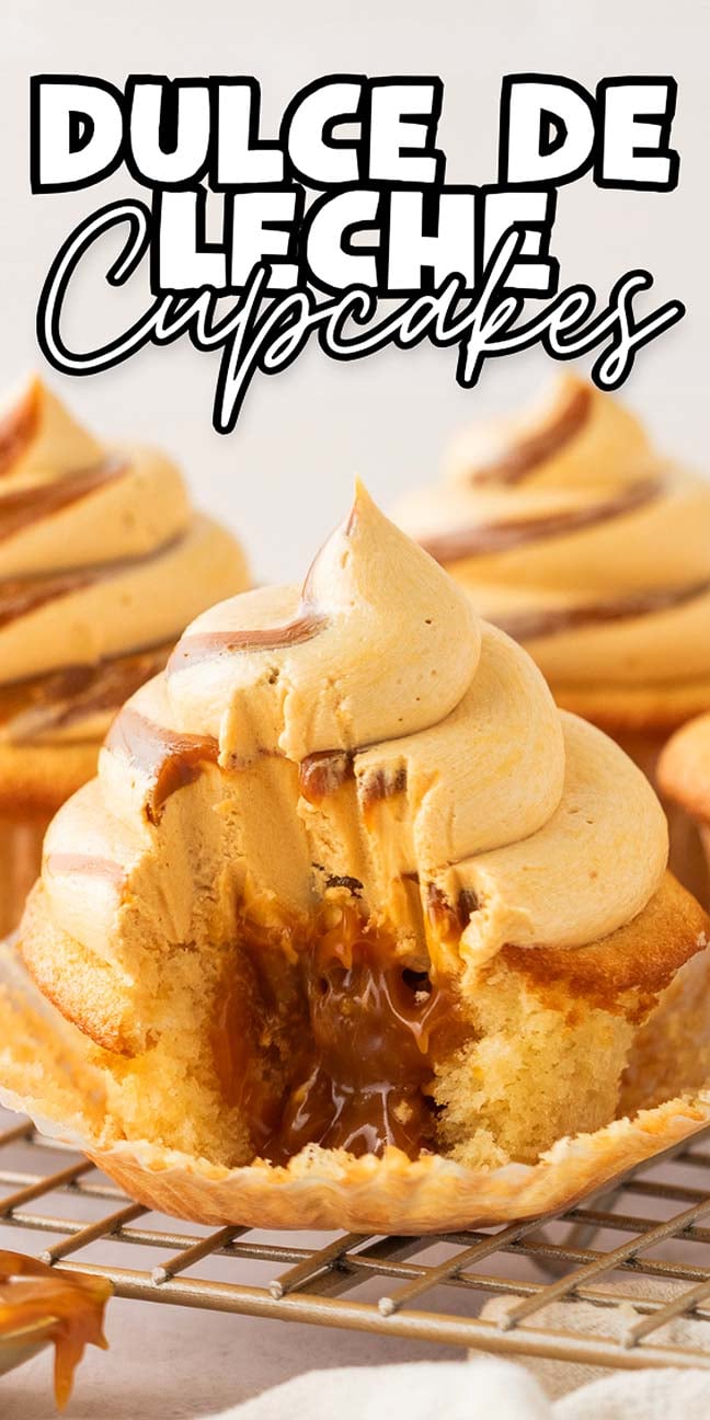 Dulce de leche cupcakes with a rich filling and swirled frosting, unwrapped and bitten, rest temptingly on a cooling rack.