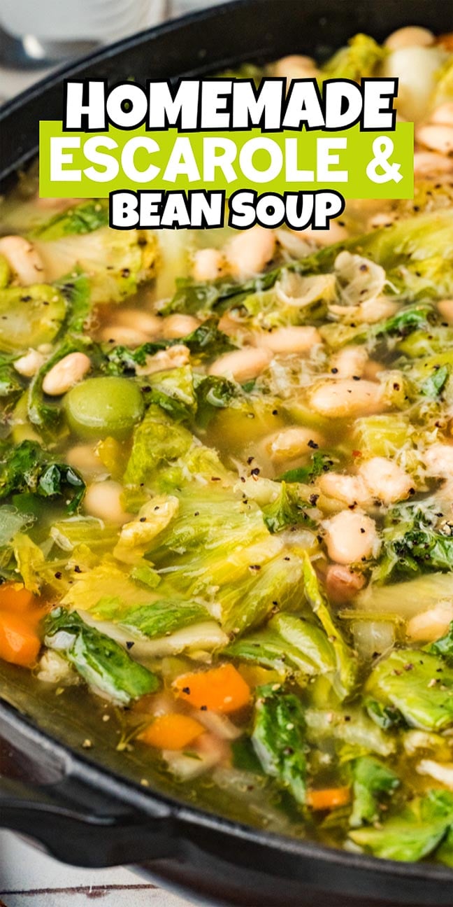 A close-up of homemade Escarole and Bean Soup, featuring carrots, beans, and leafy greens simmering together in a pot.