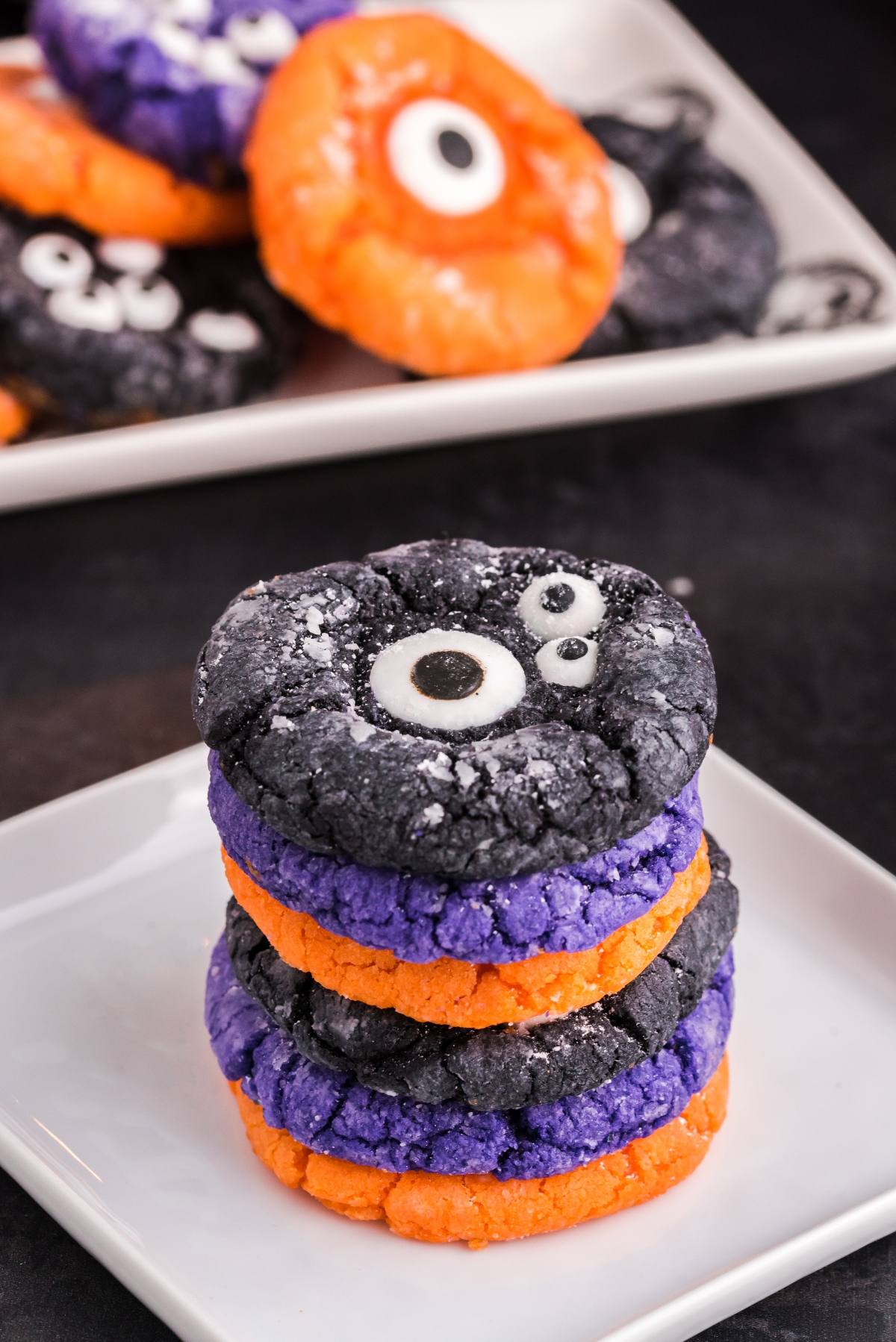 Stack of colorful Halloween Crinkle Cookies with monster eye decorations in purple, orange, and black layers&mdash;perfect for easy Halloween cookie decorating ideas using cake mix Halloween cookies.