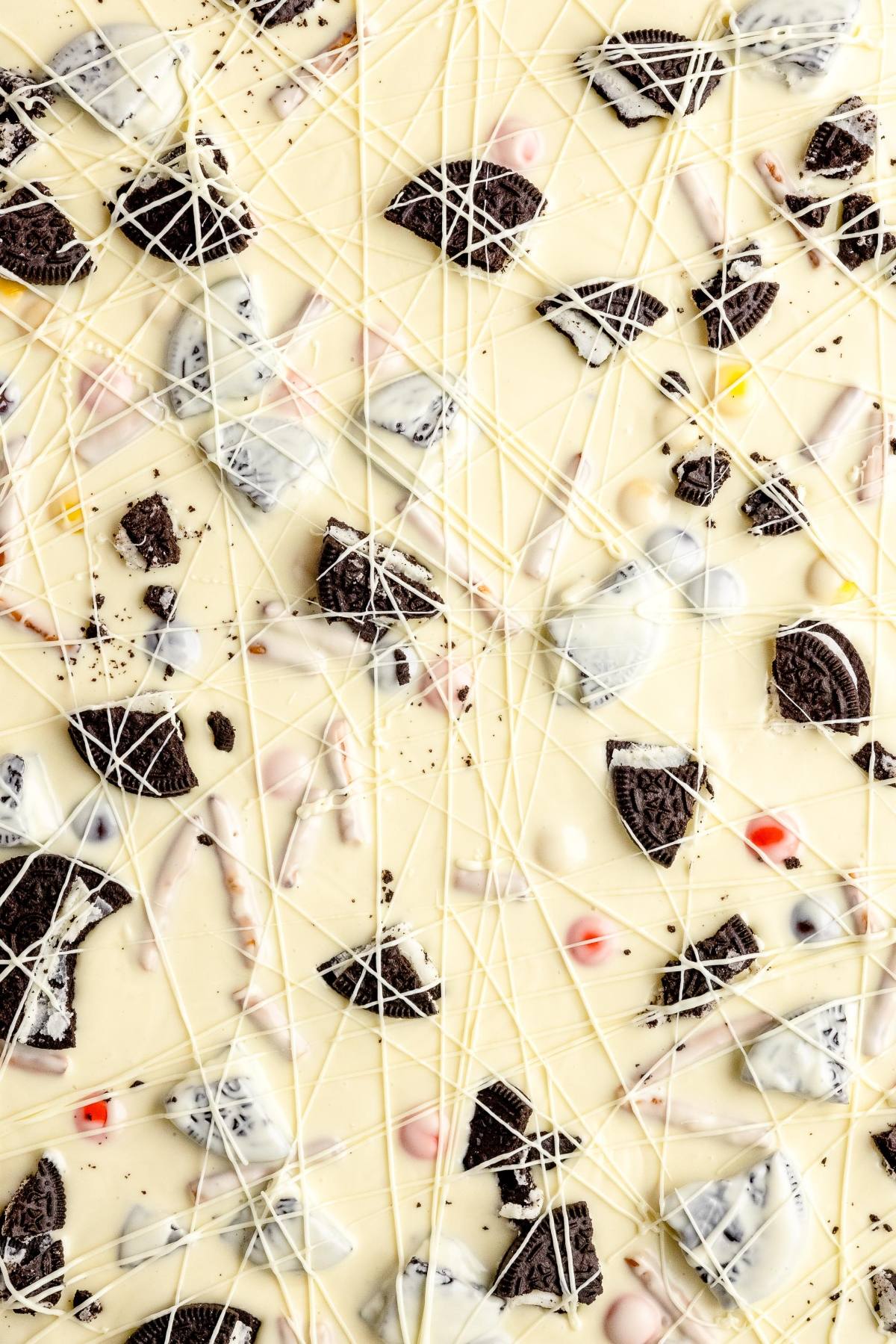 White chocolate bark with colorful candy pieces, cookie chunks, and fun googly monster eyes—this easy candy bark recipe is drizzled with more white chocolate for a perfect Halloween treat.