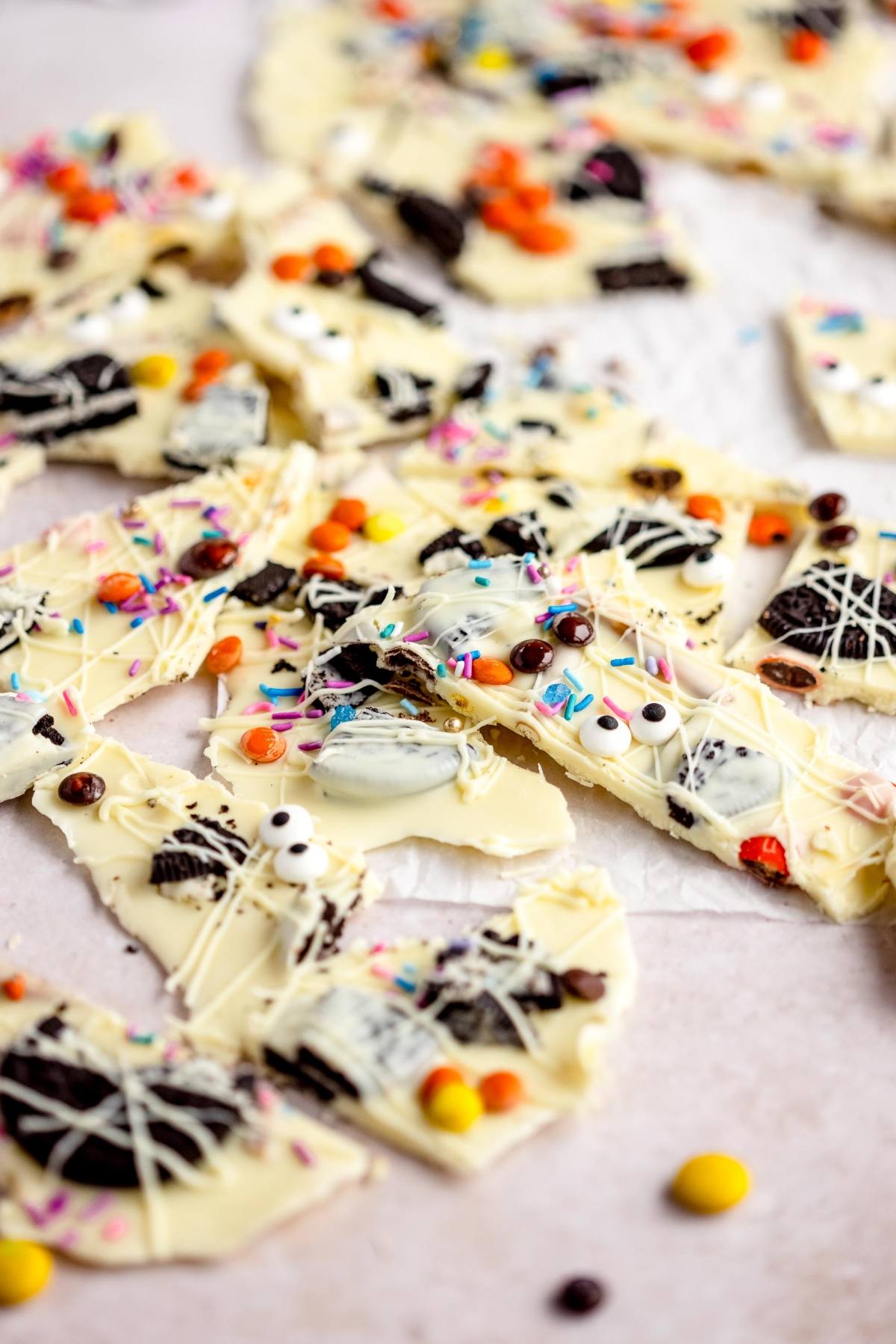 Halloween White Chocolate Candy Bark with colorful sprinkles, cookies, candies, and googly monster eyes makes a fun Halloween treat. This easy halloween bark recipe is perfect for parties and sharing with friends!.