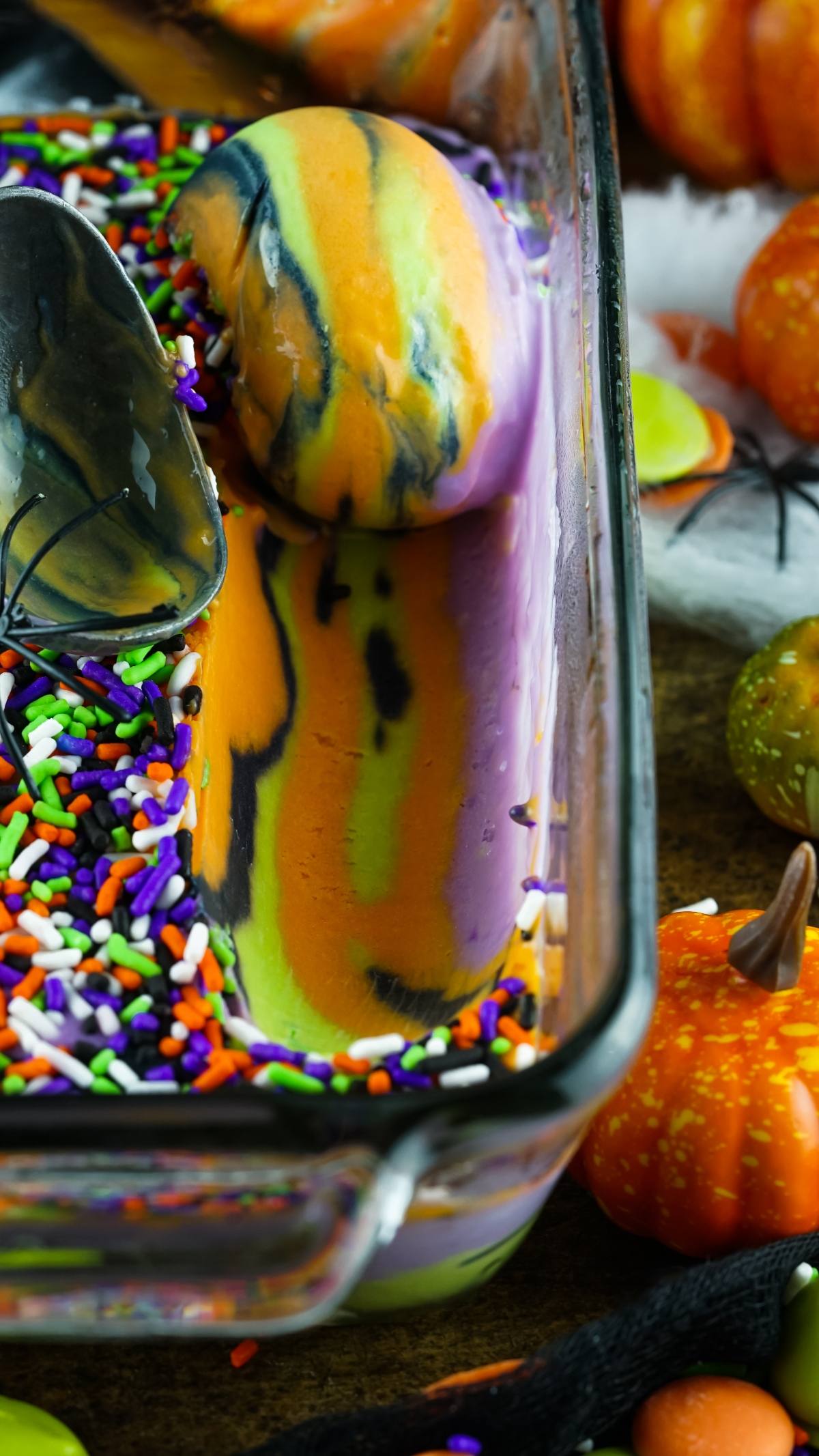 A scoop of spooky ice cream, Halloween-themed with orange, green, and purple swirls and colorful sprinkles—perfect for fans of frozen Halloween treats.