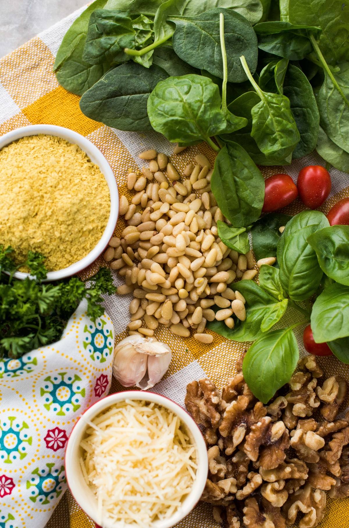 Fresh spinach, basil, grape tomatoes, pine nuts, walnuts, garlic, parsley, nutritional yeast, and grated cheese come together for a vibrant vegan pesto sauce.