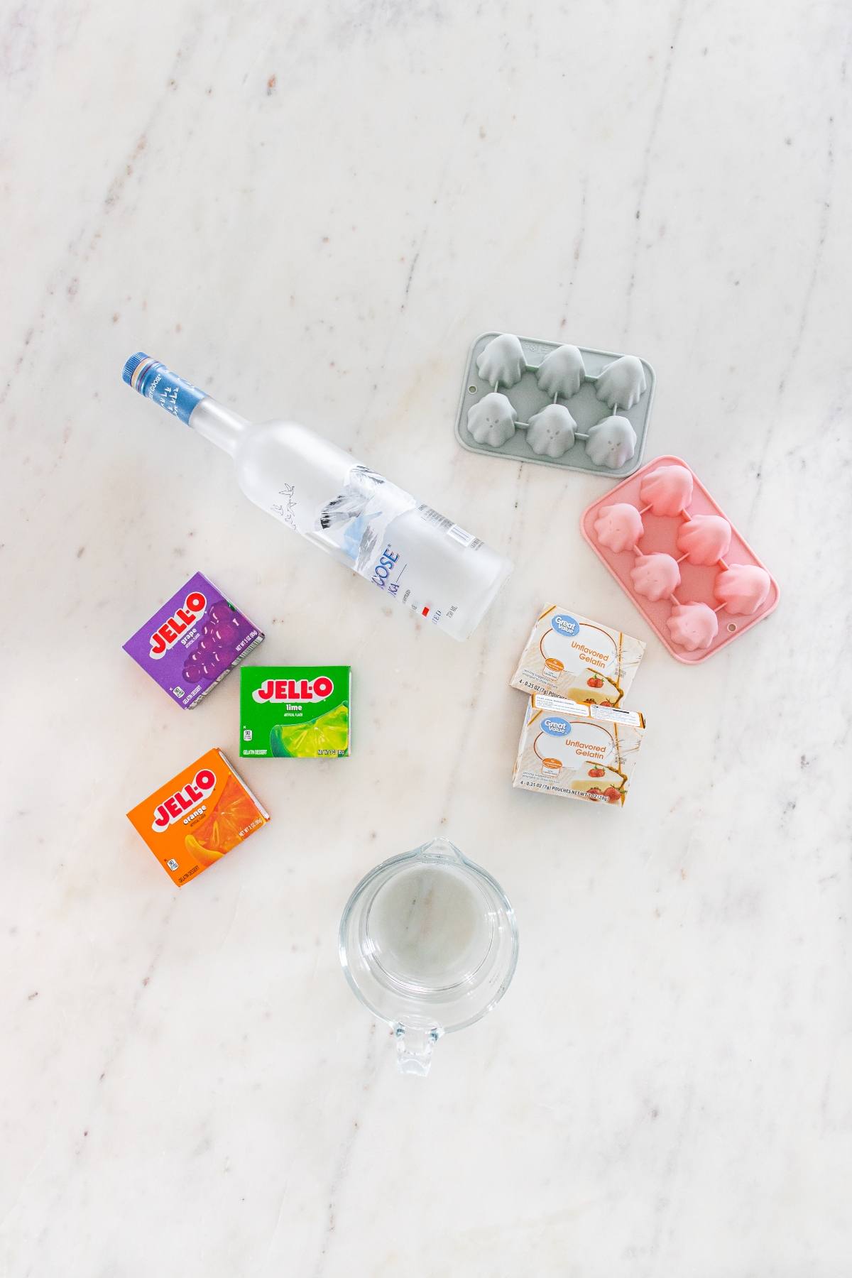 Bottled vodka, Jell-O boxes, cream cheese, egg cartons, and a glass pitcher on a marble countertop.