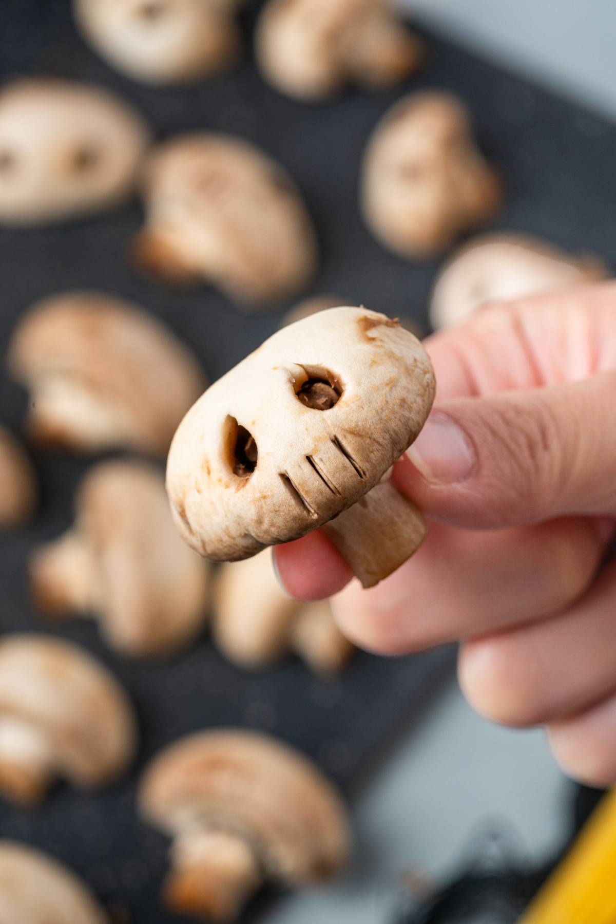 A hand holding a mushroom.