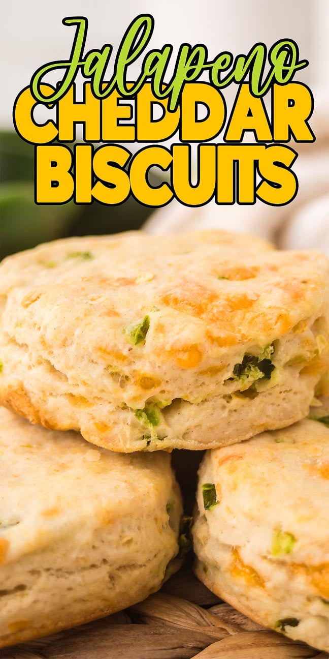 Three flaky biscuits with cheddar cheese and jalapeño pieces, stacked under text reading "Jalapeño Cheddar Biscuits." Enjoy the spicy kick and cheesy goodness of these Jalapeño Cheddar Biscuits.