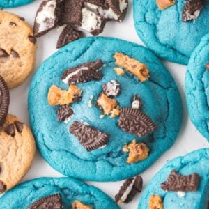 Oreo Stuffed Cookie Monster Cookies: Blue cookies topped with crushed chocolate sandwich cookies, surrounded by chocolate chip and sandwich cookies.