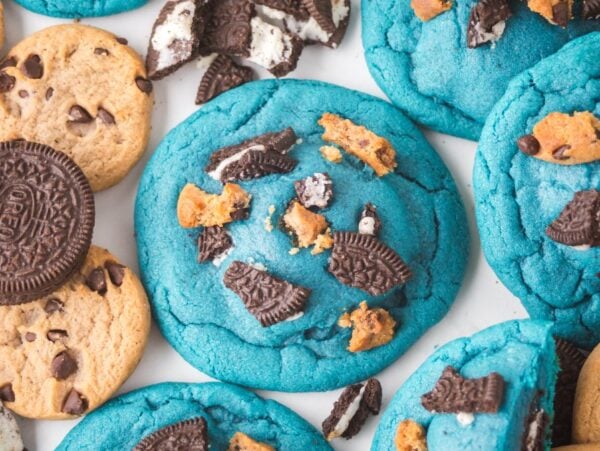 Oreo Stuffed Cookie Monster Cookies: Blue cookies topped with crushed chocolate sandwich cookies, surrounded by chocolate chip and sandwich cookies.