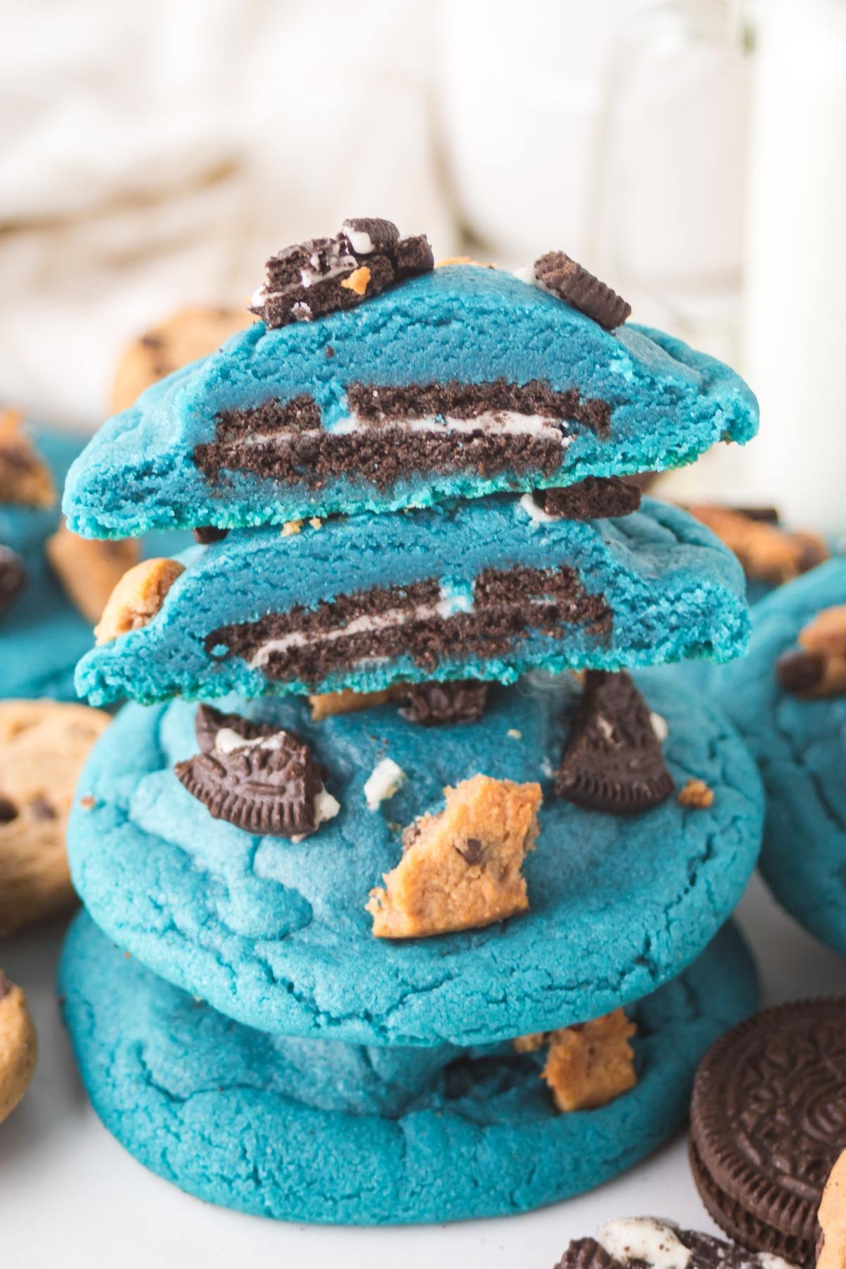 Bright blue cookies with Oreo and chocolate chip cookie pieces, stacked on top of each other.