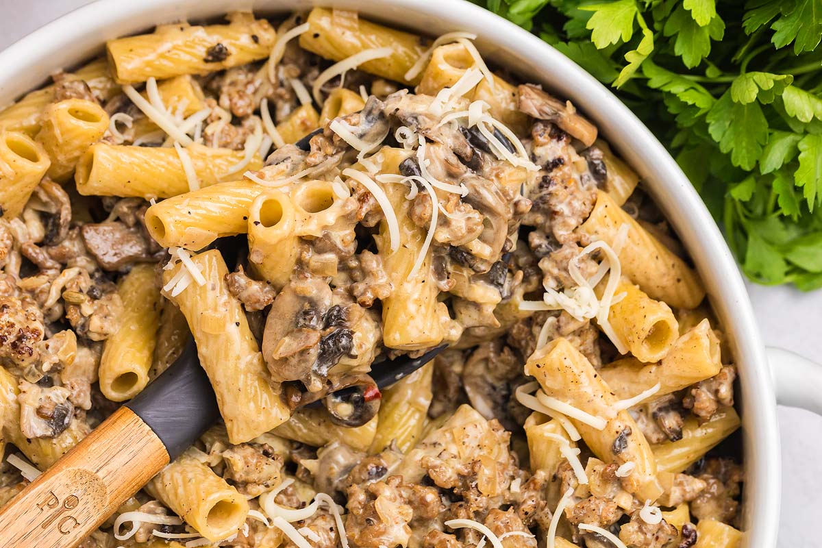 Creamy pasta alla Norcina with ground meat, mushrooms, and shredded cheese, garnished with fresh parsley.