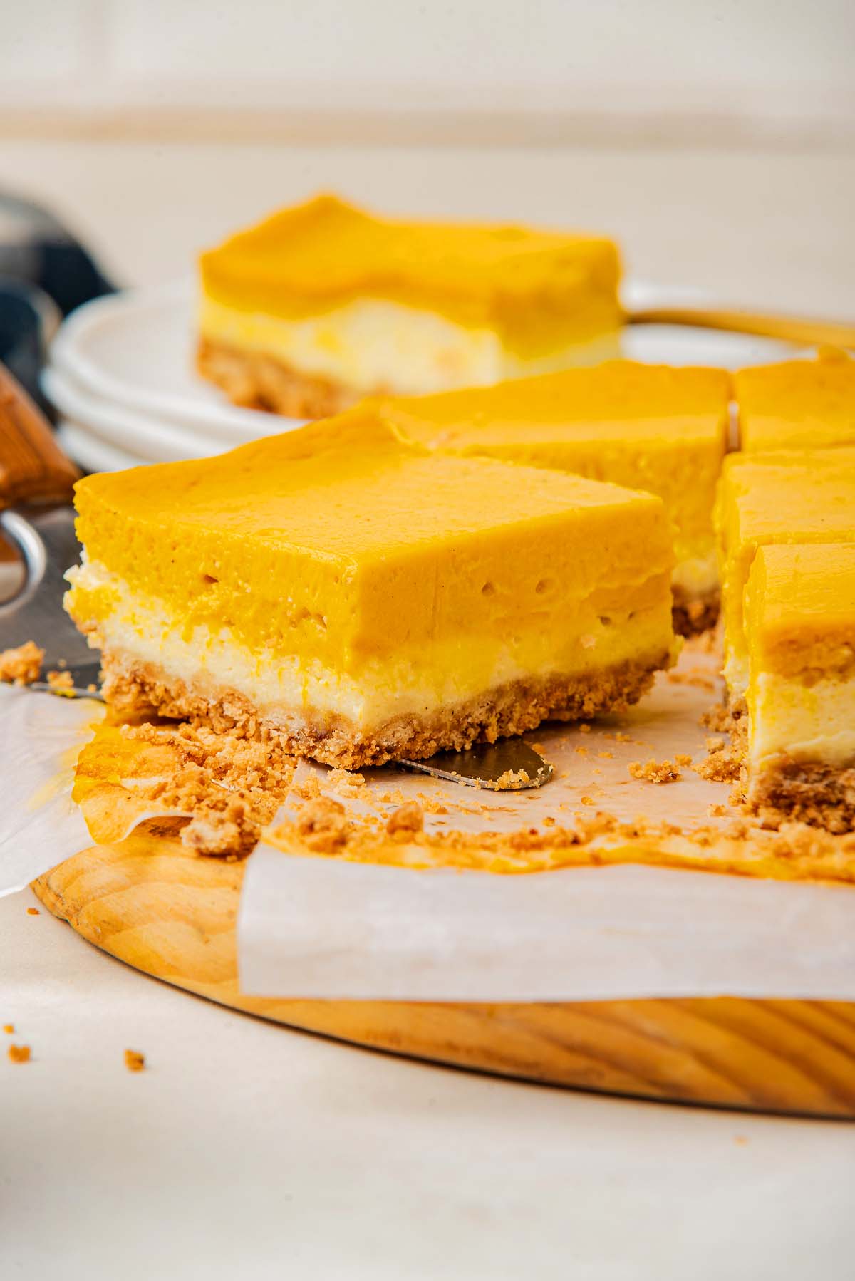 Sliced pumpkin cheesecake bars with a graham cracker crust.