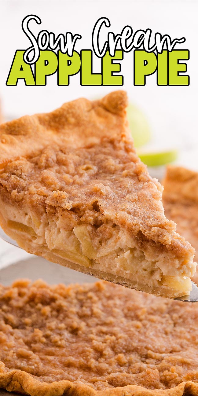 A delicious slice of sour cream apple pie is being lifted from a whole pie, showcasing its golden crumb topping.