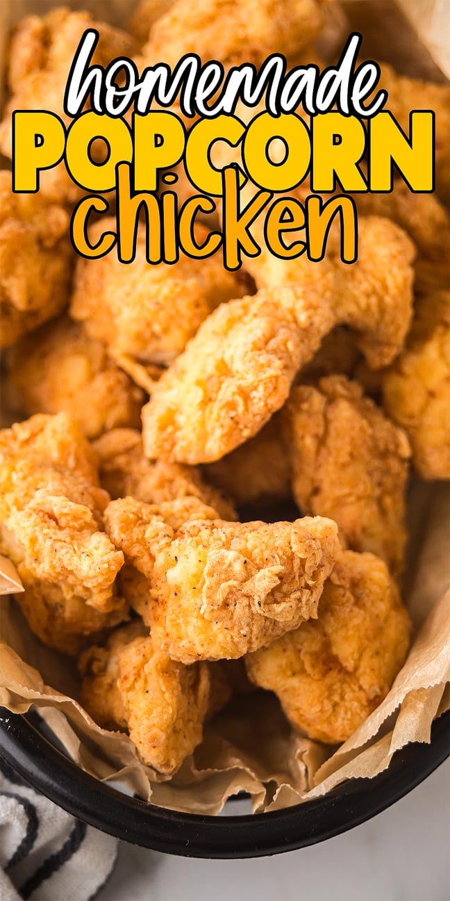 Basket of crispy popcorn chicken on parchment paper, with bold text reading "homemade popcorn chicken.