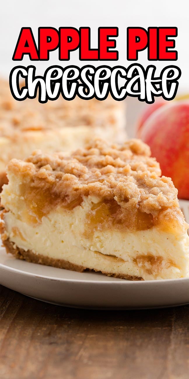 A slice of apple pie cheesecake on a plate, with a fresh apple and more apple pie cheesecake in the background.