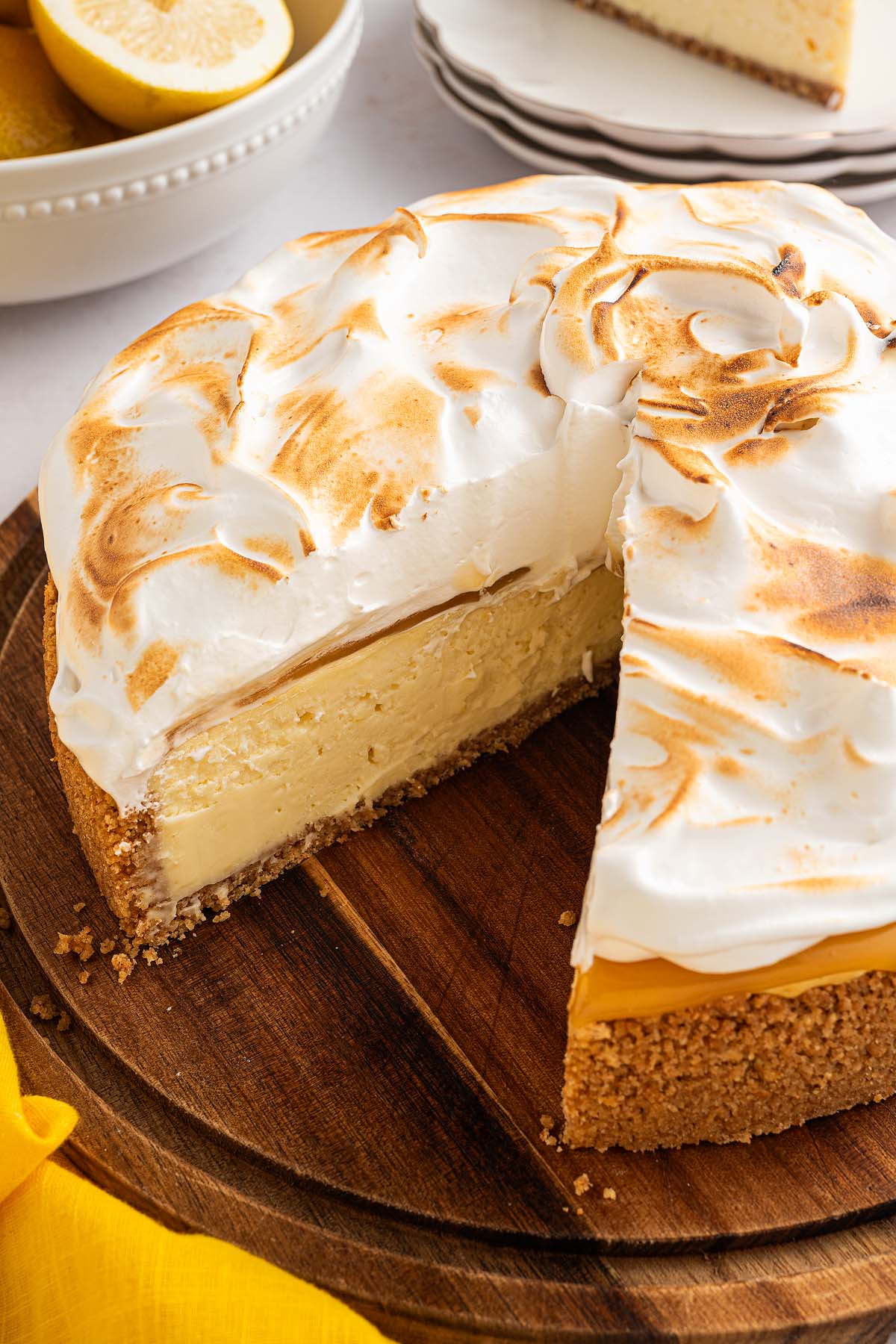 Lemon Meringue Cheesecake with a slice cut out, revealing creamy layers and a perfectly toasted meringue topping.