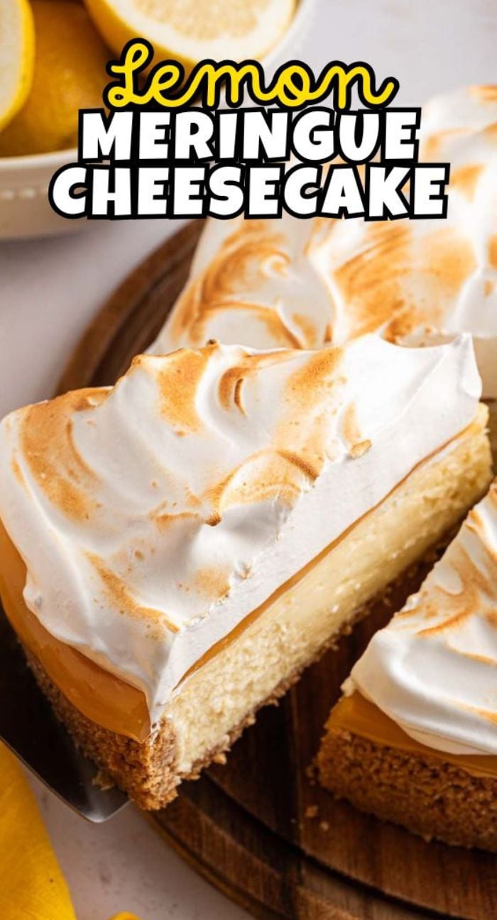 A slice of Lemon Meringue Cheesecake topped with golden-brown meringue sits on a wooden board, tempting you with its zesty, creamy layers and beautiful presentation.