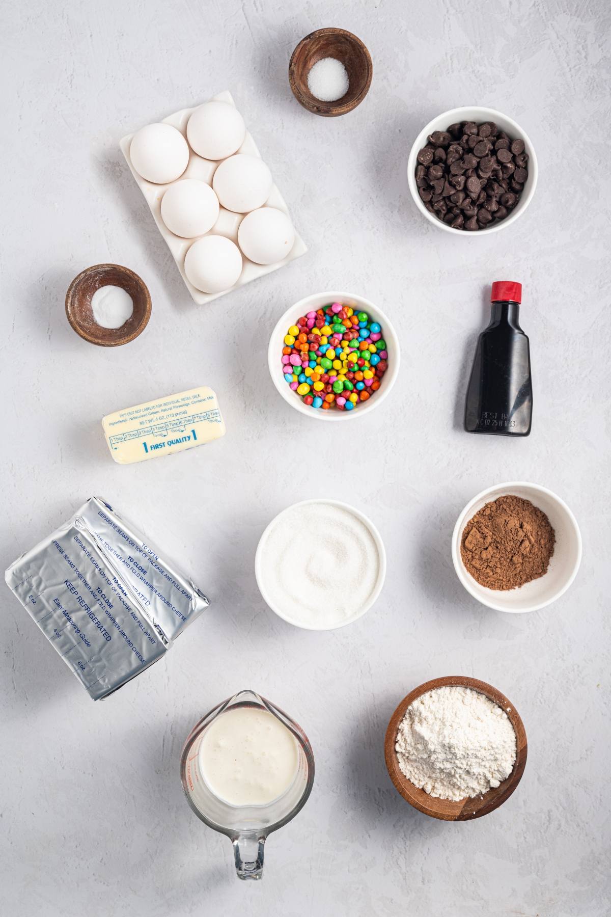 Baking ingredients including eggs, sugar, flour, butter, cream, chocolate chips, cocoa, candies, and vanilla.