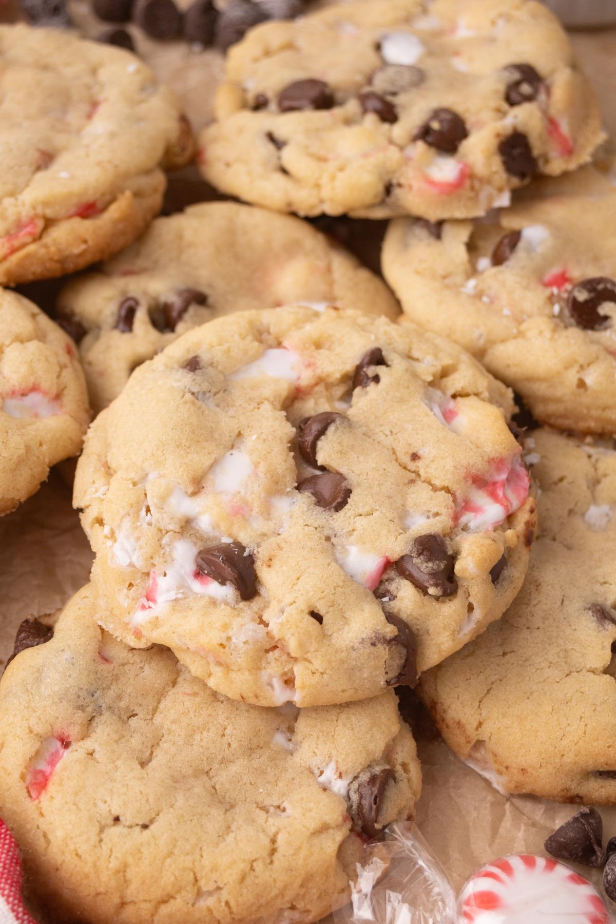 Chocolate chip cookies with pieces of peppermint and melted marshmallow on parchment paper.