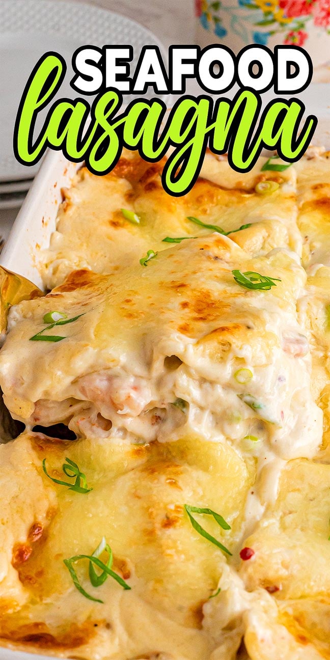 A cheesy, creamy seafood lasagna in a white baking dish, topped with melted cheese and green onion slices, makes this seafood lasagna an irresistible comfort food favorite.