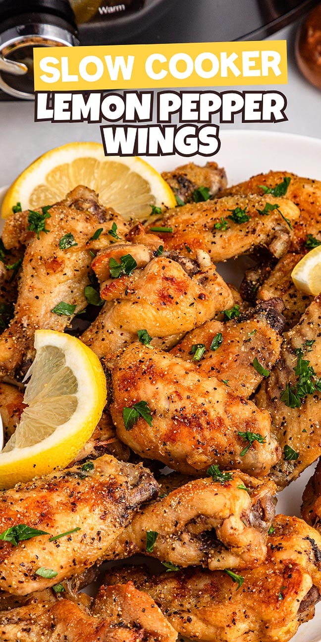 A plate of slow cooker lemon pepper wings garnished with parsley and lemon slices, with a slow cooker in the background.