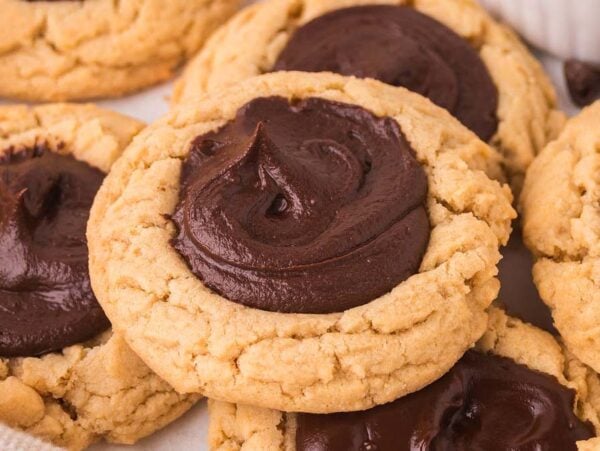 Close-up of Chocolate Thumbprint Cookies, topped with swirls of rich chocolate frosting.