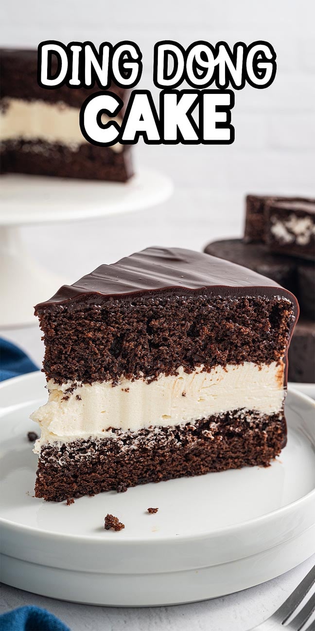 A slice of decadent Ding Dong Cake with creamy filling rests on a white plate, while the whole cake tempts in the background.