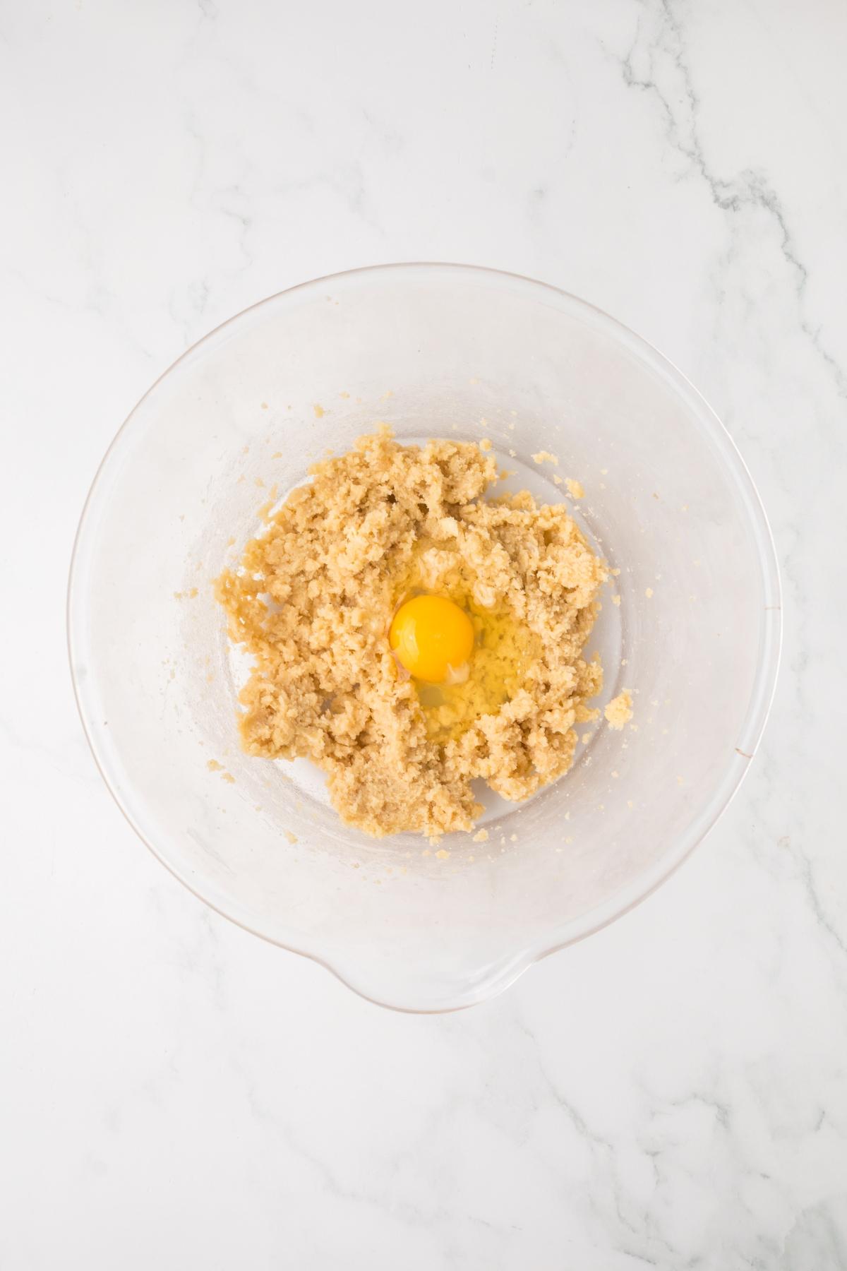 A bowl of dough with a yolk in it.