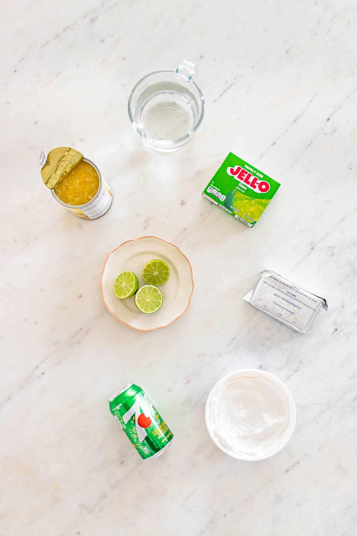 Ingredients for key lime pie: limes, whipped topping, pineapple, cream cheese, Sprite, Jello mix, and water.