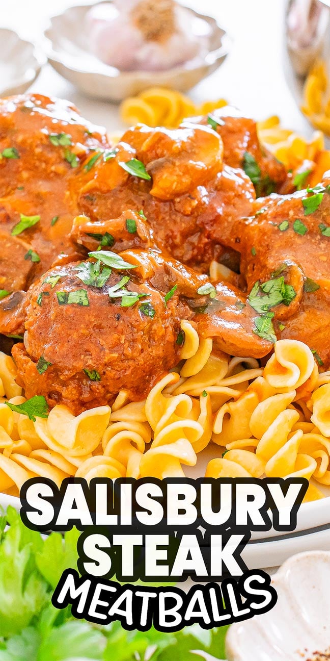 Salisbury Steak Meatballs with rich brown gravy and mushrooms served over egg noodles, garnished with parsley.