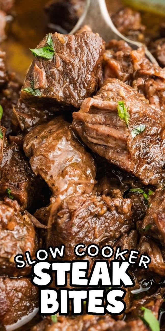 Tender, juicy Slow Cooker Steak Bites garnished with herbs, shown up close with a spoon and the text "Slow Cooker Steak Bites.