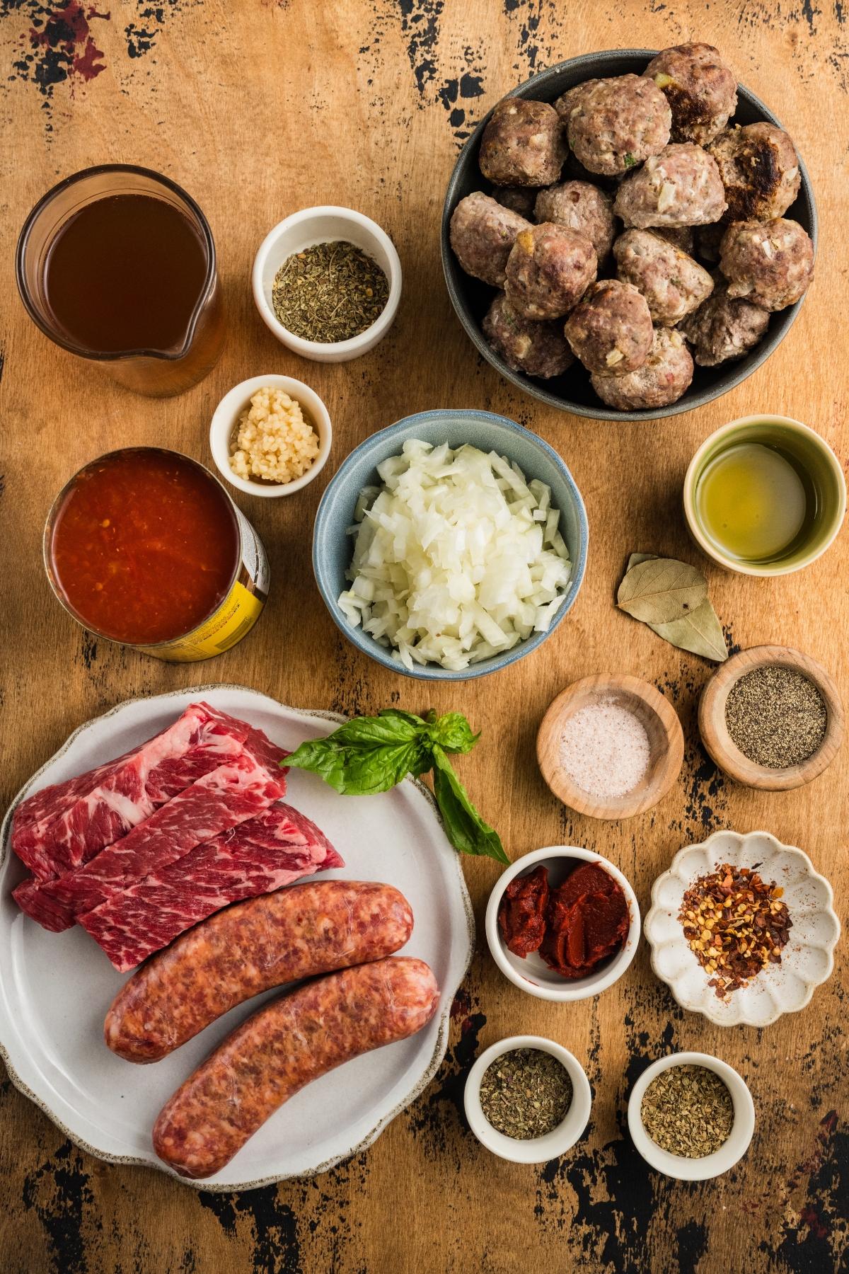 Ingredients for Italian meat sauce, including meats, spices, herbs, onions, tomato paste, sauce, and broths.