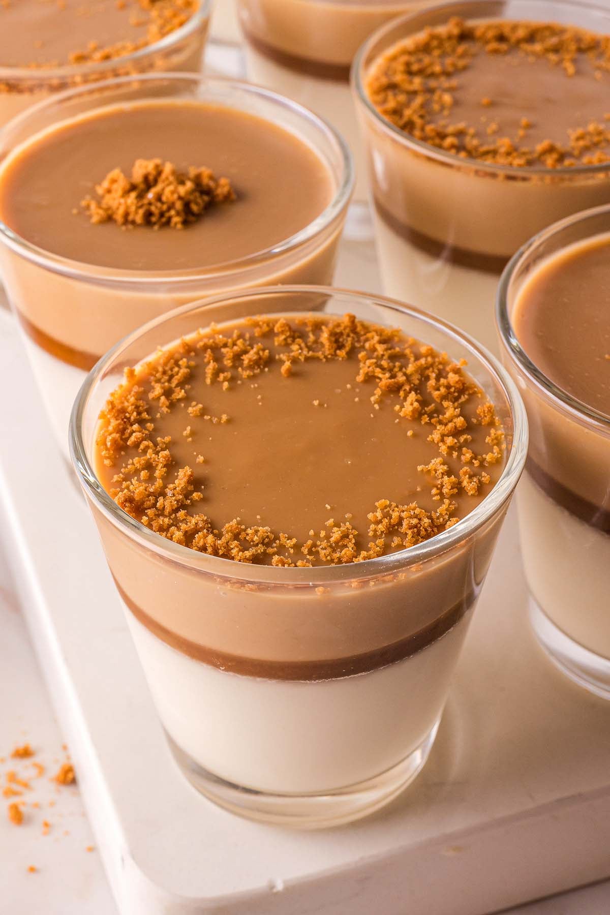A group of glasses filled with delightful desserts, including creamy Biscoff Panna Cotta.