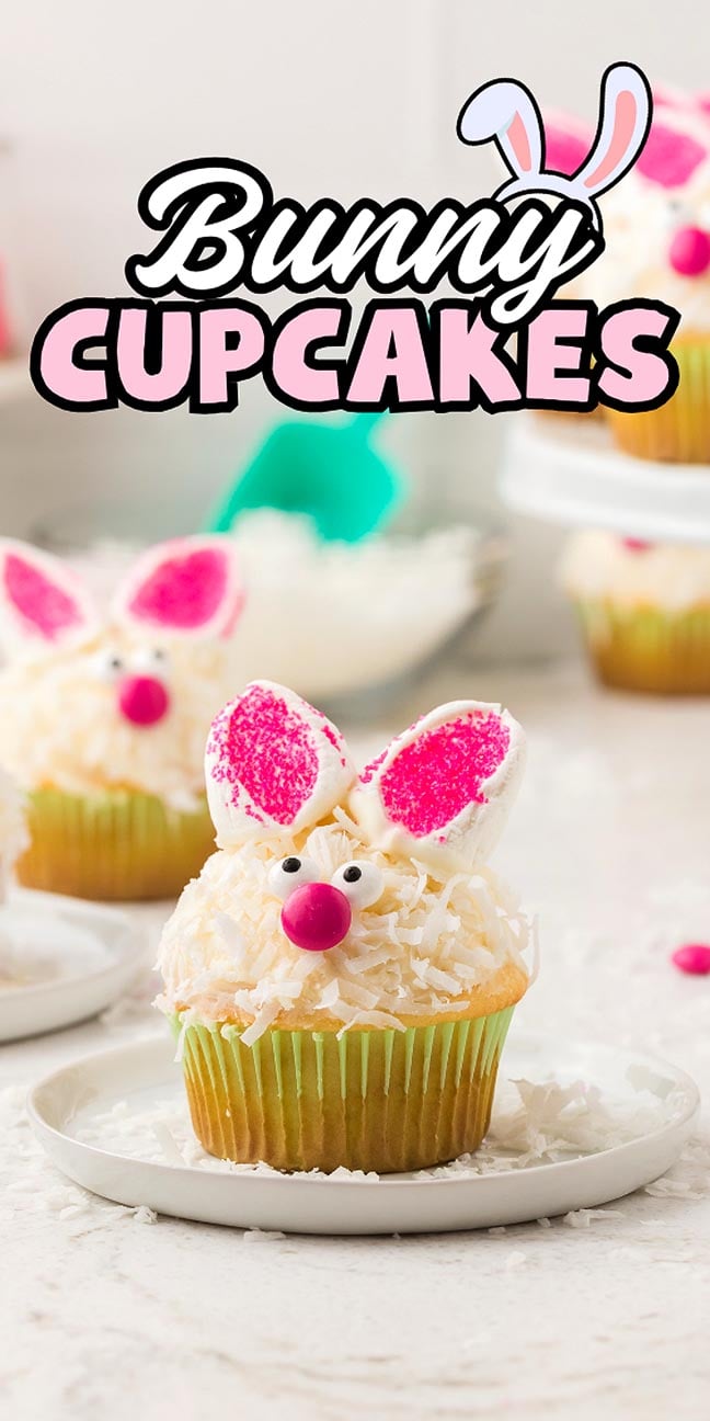 A bunny cupcake with pink ears, candy eyes, and a pink nose sits on a white plate—perfect for anyone who loves adorable bunny cupcakes.