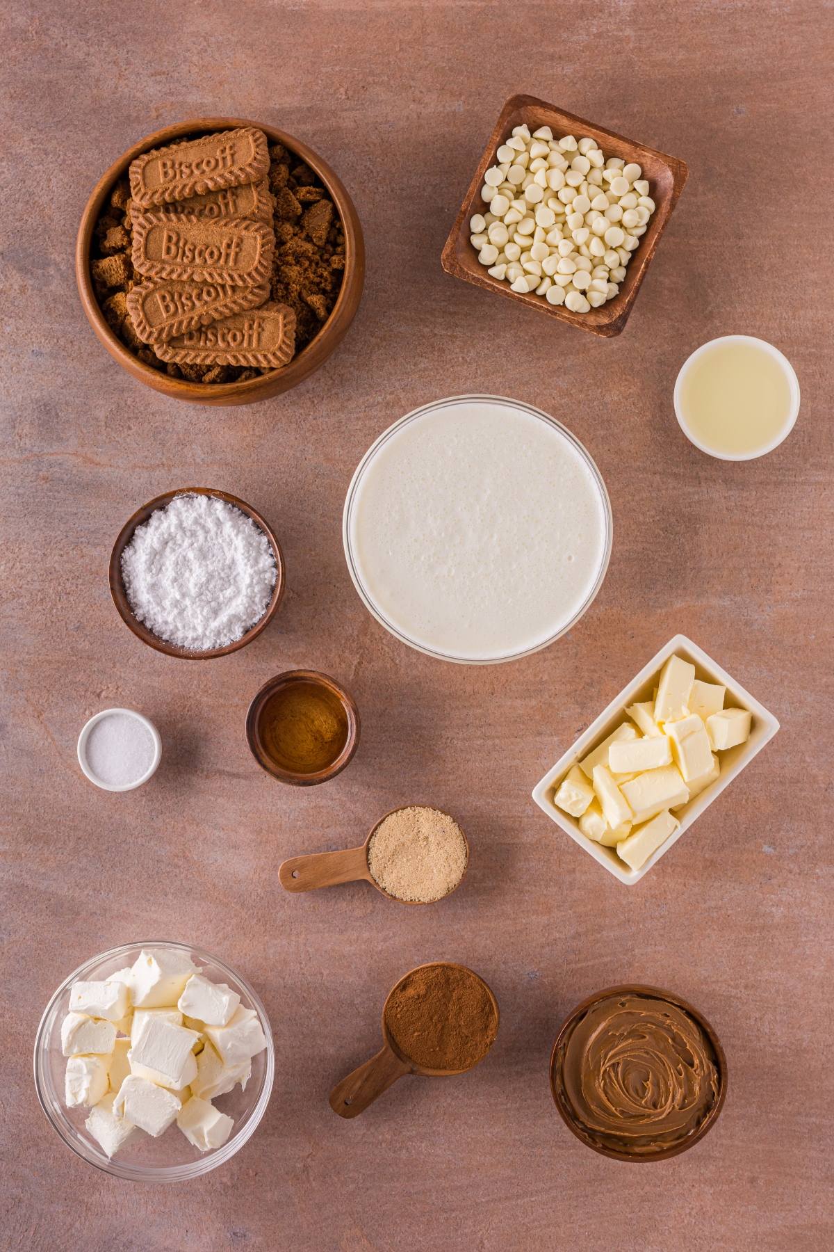 Ingredients arranged on a countertop, including cookies, chocolate chips, butter, cream, sugar, and spices.