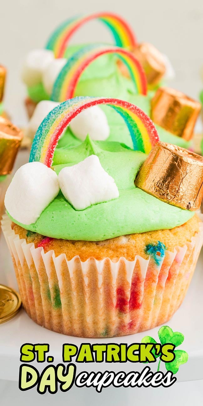 A cupcake with green frosting, a candy rainbow, marshmallows, and a gold chocolate—perfect St. Patrick's Day Cupcakes for your celebration!.