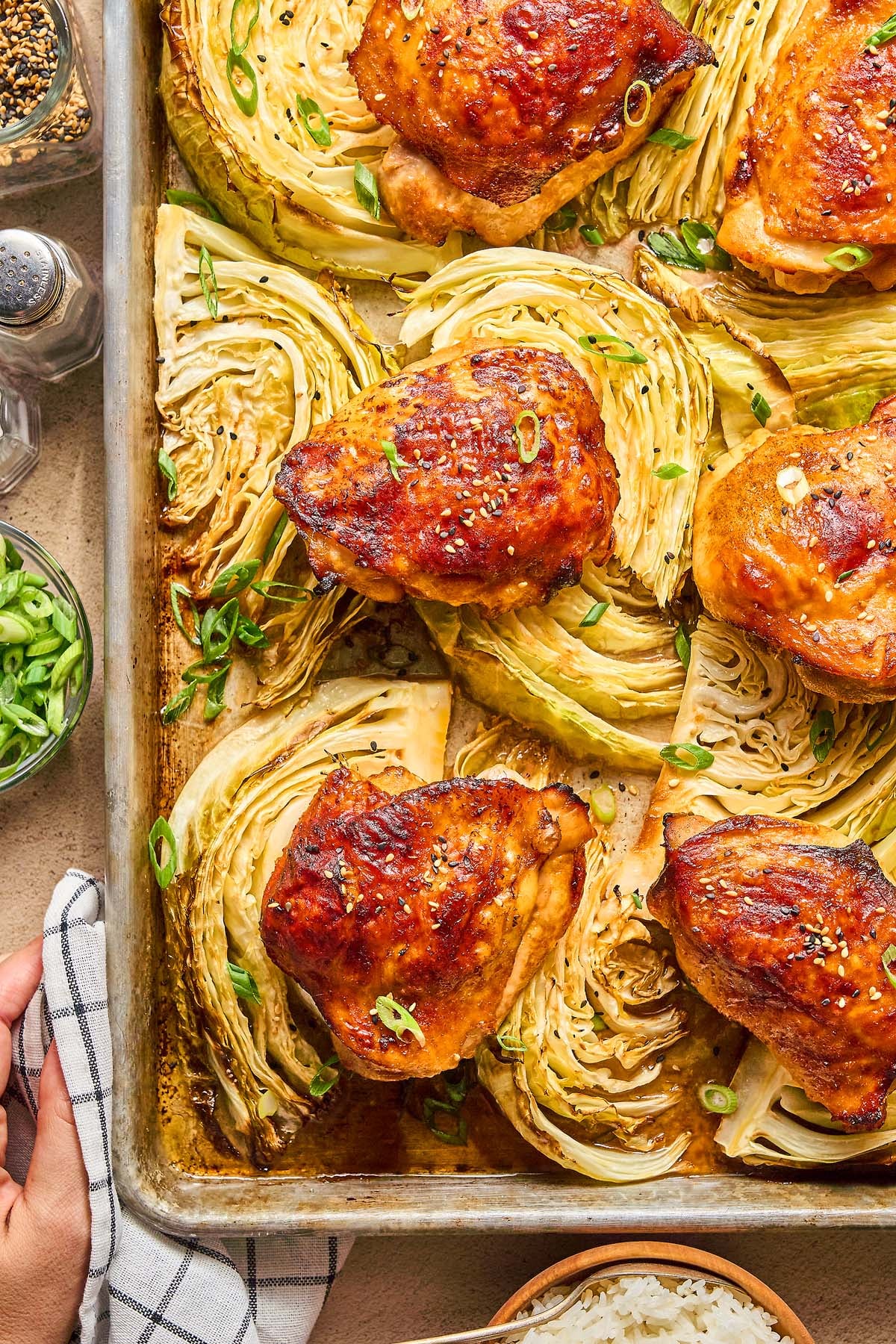 Sheet Pan Gochujang Chicken and Cabbage features roasted chicken thighs and cabbage wedges on a sheet pan, all garnished with sliced green onions.
