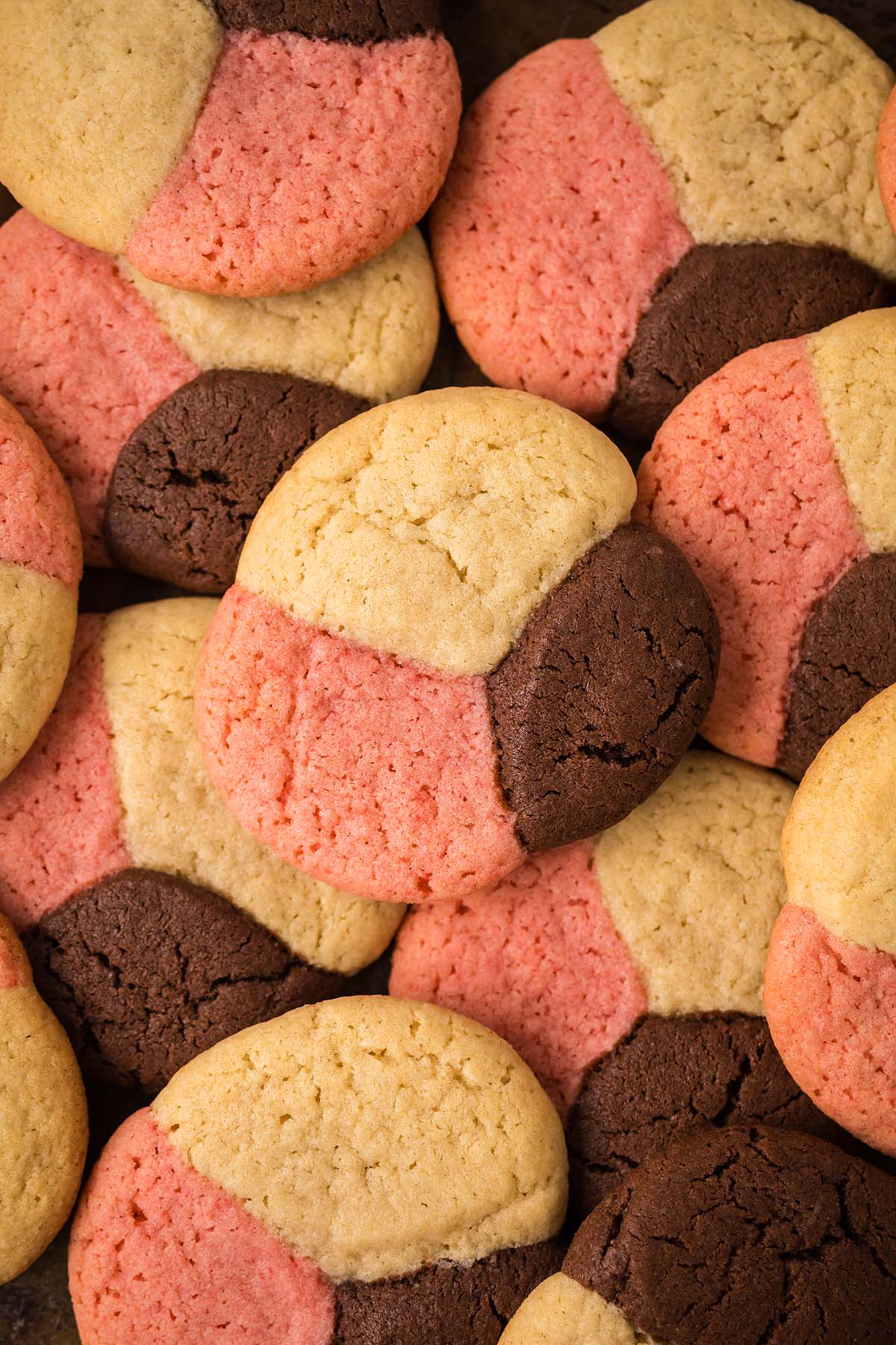A pile of Neapolitan Cookies with vanilla, chocolate, and pink sections.