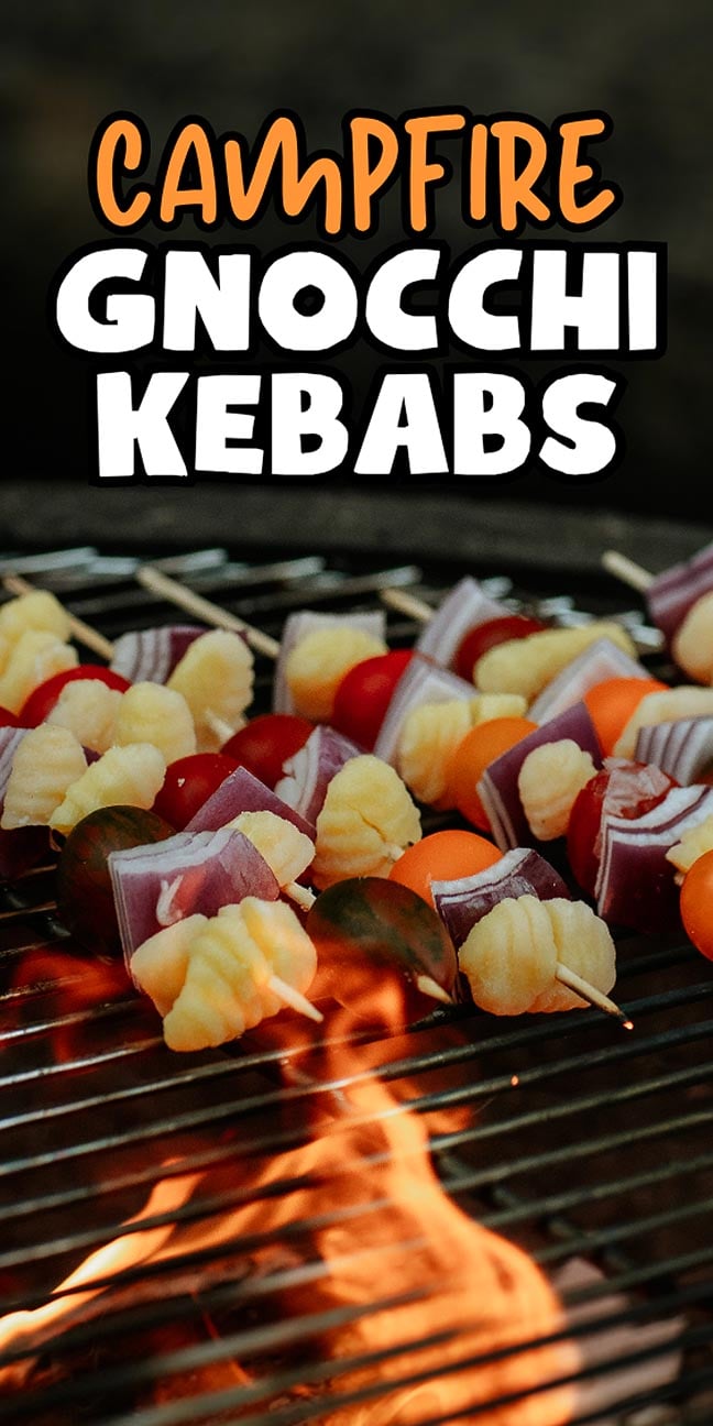 Campfire grill with skewers of gnocchi, onion, and cherry tomatoes above a flame. Text: "Campfire Gnocchi Kebabs—enjoy this delicious twist on classic campfire cooking.
