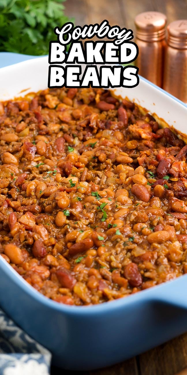 A blue baking dish filled with savory cowboy baked beans, topped with fresh herbs; text reads "Cowboy Baked Beans.