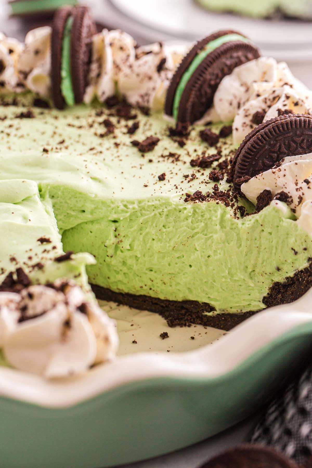 A classic grasshopper pie, this mint green dessert features a chocolate crust, topped with whipped cream and chocolate sandwich cookies.