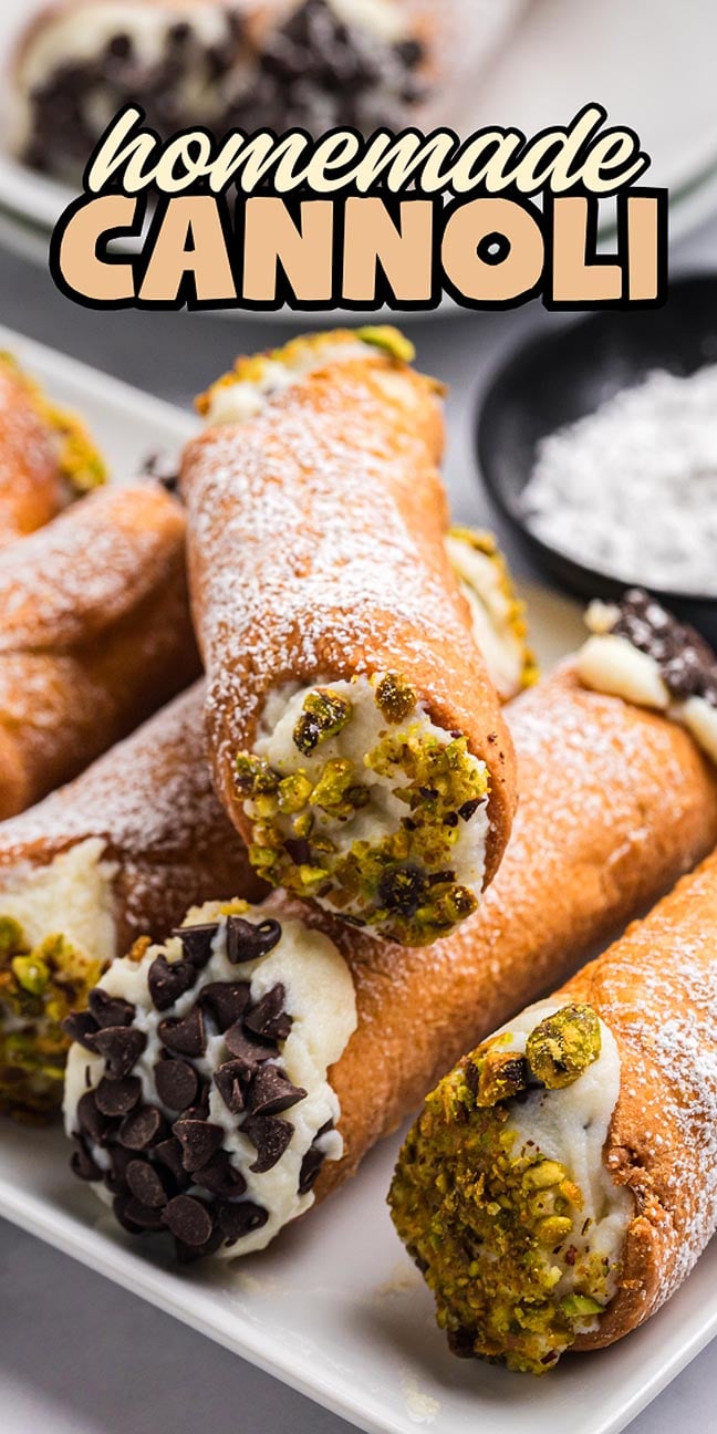 Close-up of homemade cannoli filled with chocolate chips and pistachios, dusted with powdered sugar on a plate. Enjoy the irresistible charm of fresh, homemade cannoli in every bite.