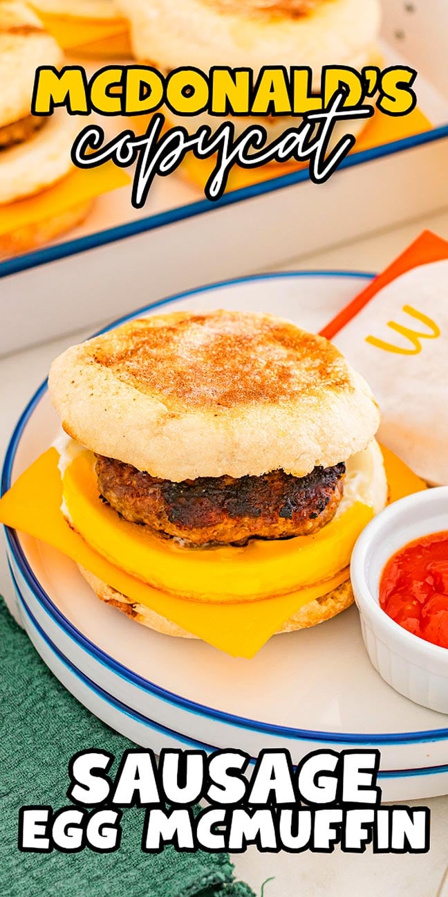 A homemade McDonalds Copycat Sausage Egg McMuffin with cheese sits on a plate, served beside ketchup and a wrapped sandwich.